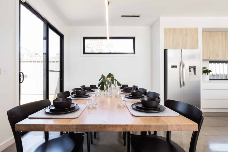 close black sliding patio door with large dining table and modern kitchen.