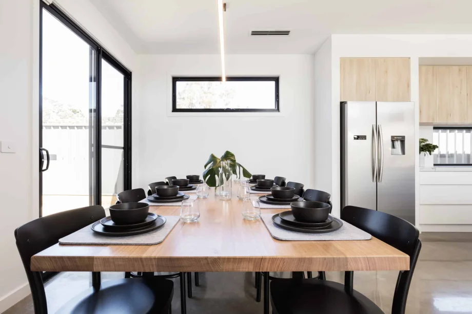 close black sliding patio door with large dining table and modern kitchen.