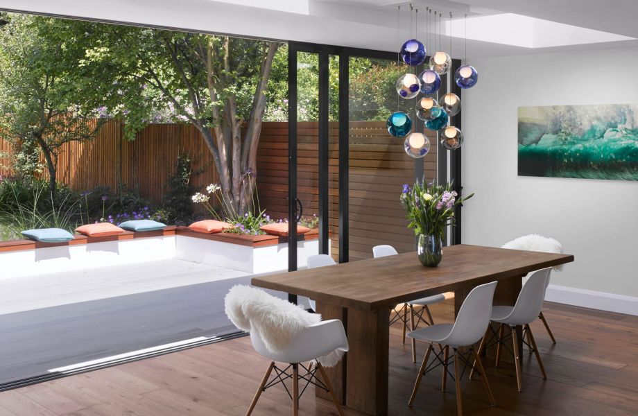 open three pane sliding patio door with large oak table and white chairs