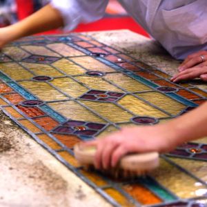 Artisans brushing stained glass windows