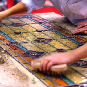 Artisans brushing stained glass windows