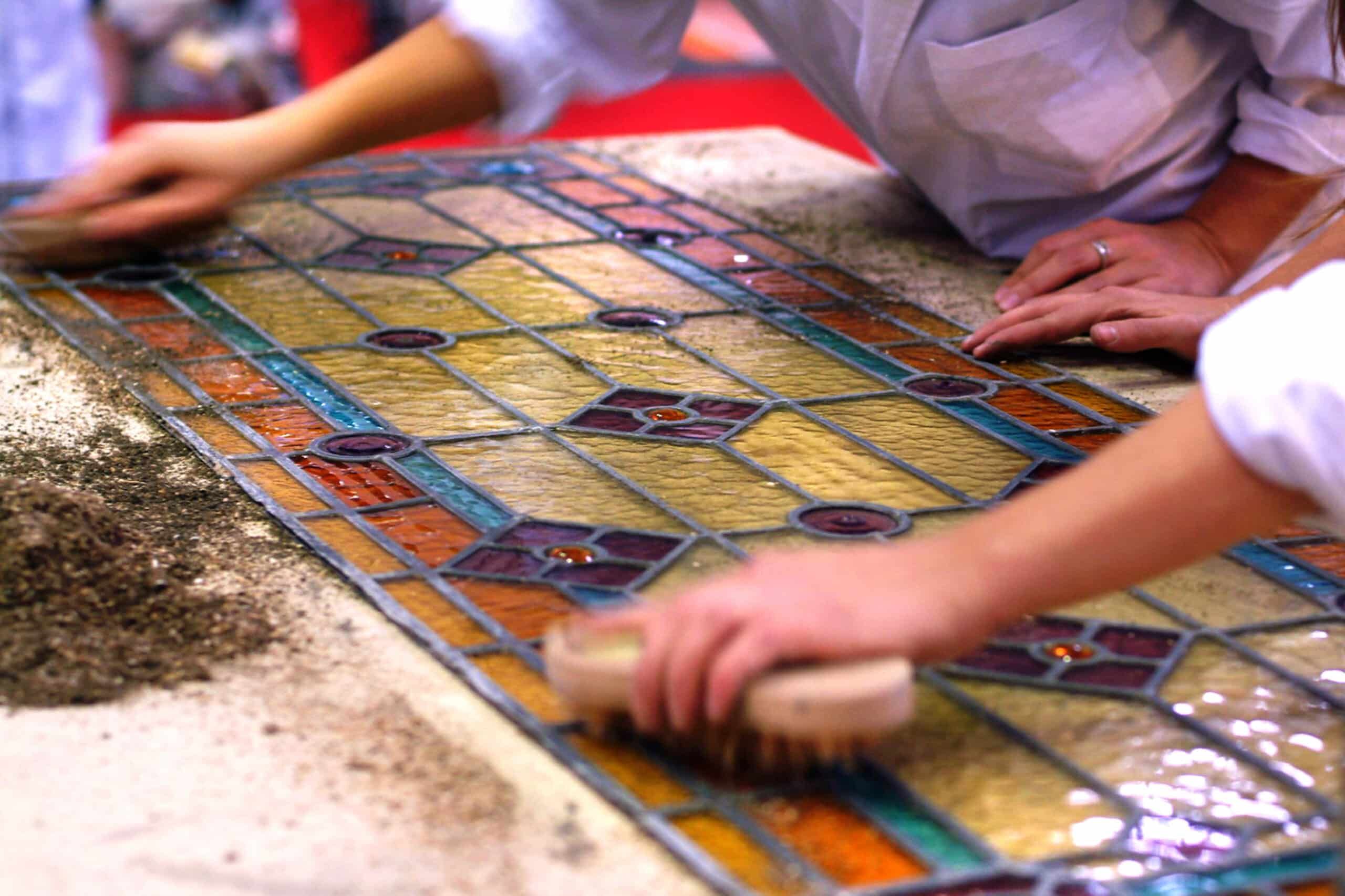 Artisans brushing stained glass windows