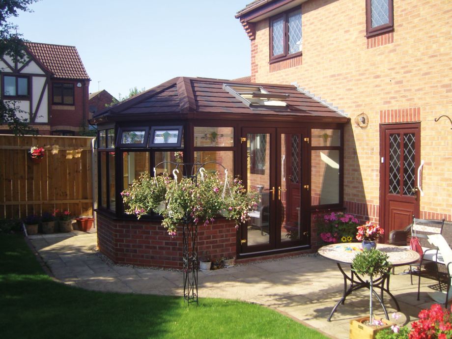 External view of guardian warm roof with rosewood coloured window frames and french doors.