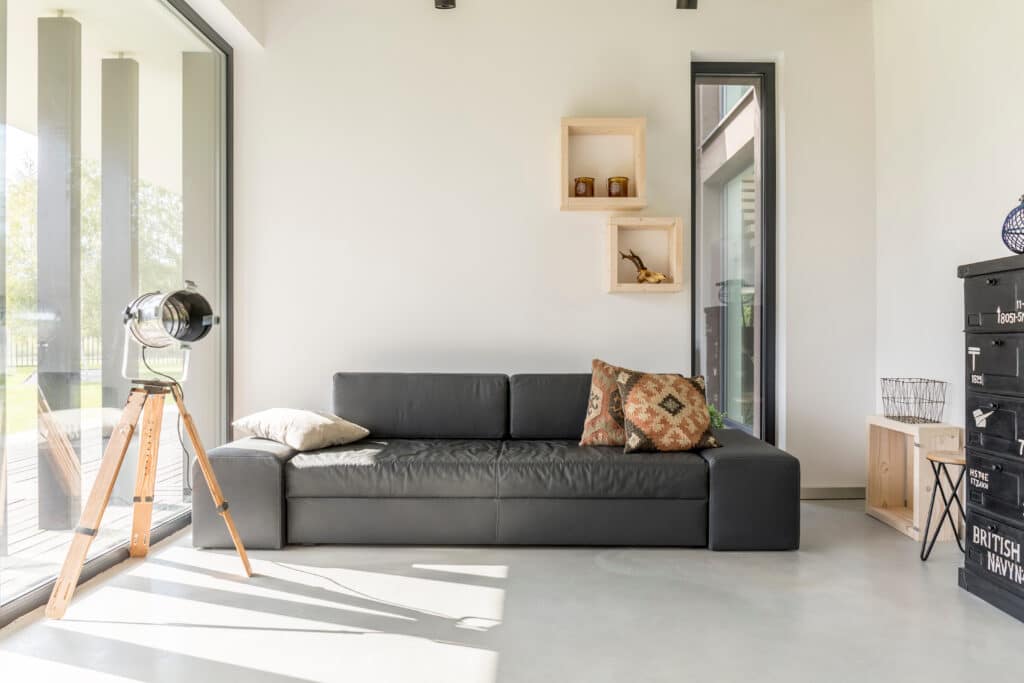 Dark grey windows with large panes of glass provide a stylish contrast to crisp white walls, 
framing this industrial-style interior