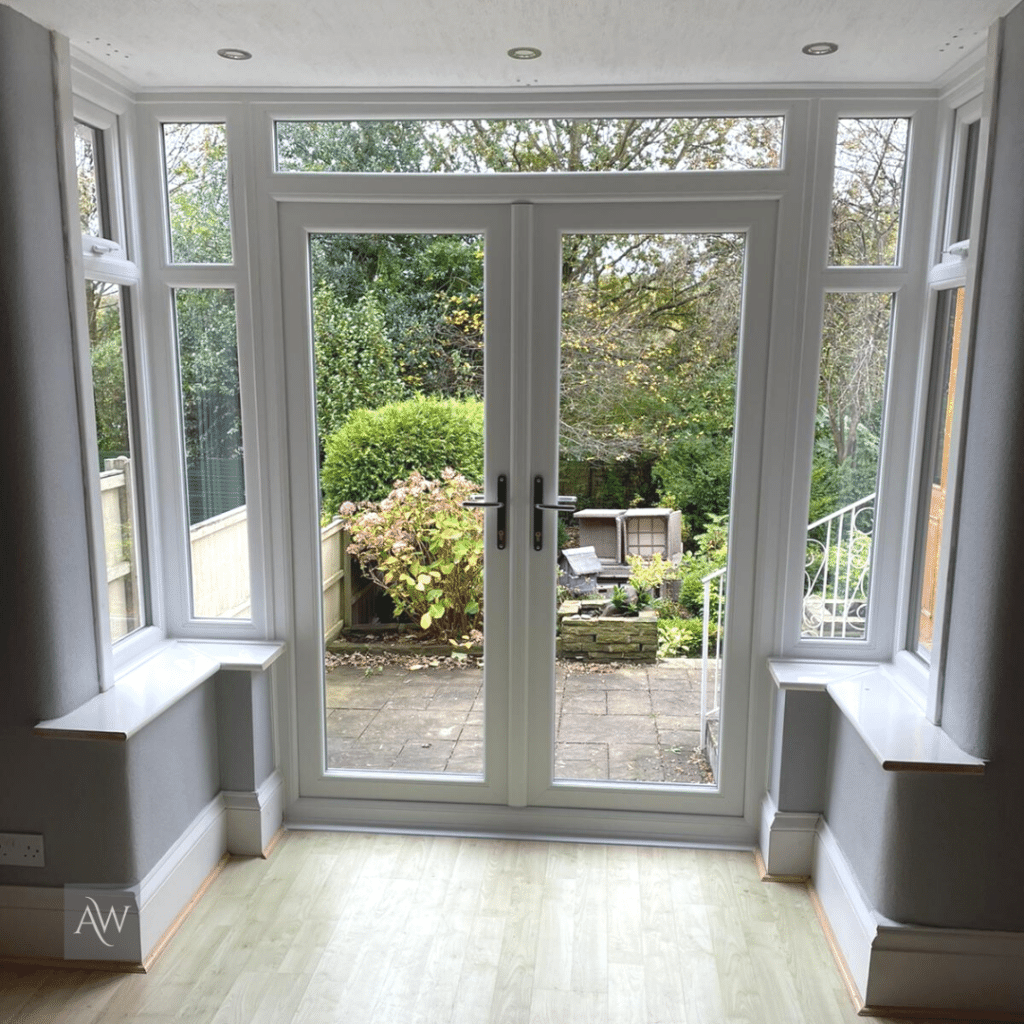 alexander windows installation of french doors with side lights leading out onto a garden patio.