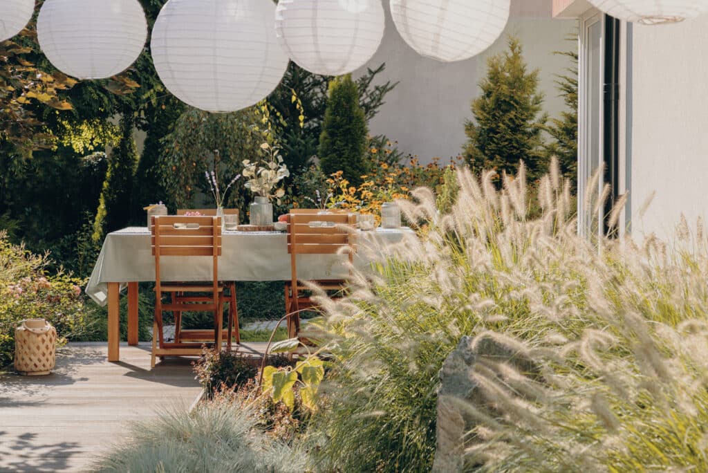 Outdoor dining set in patio with beautiful garden and lanterns