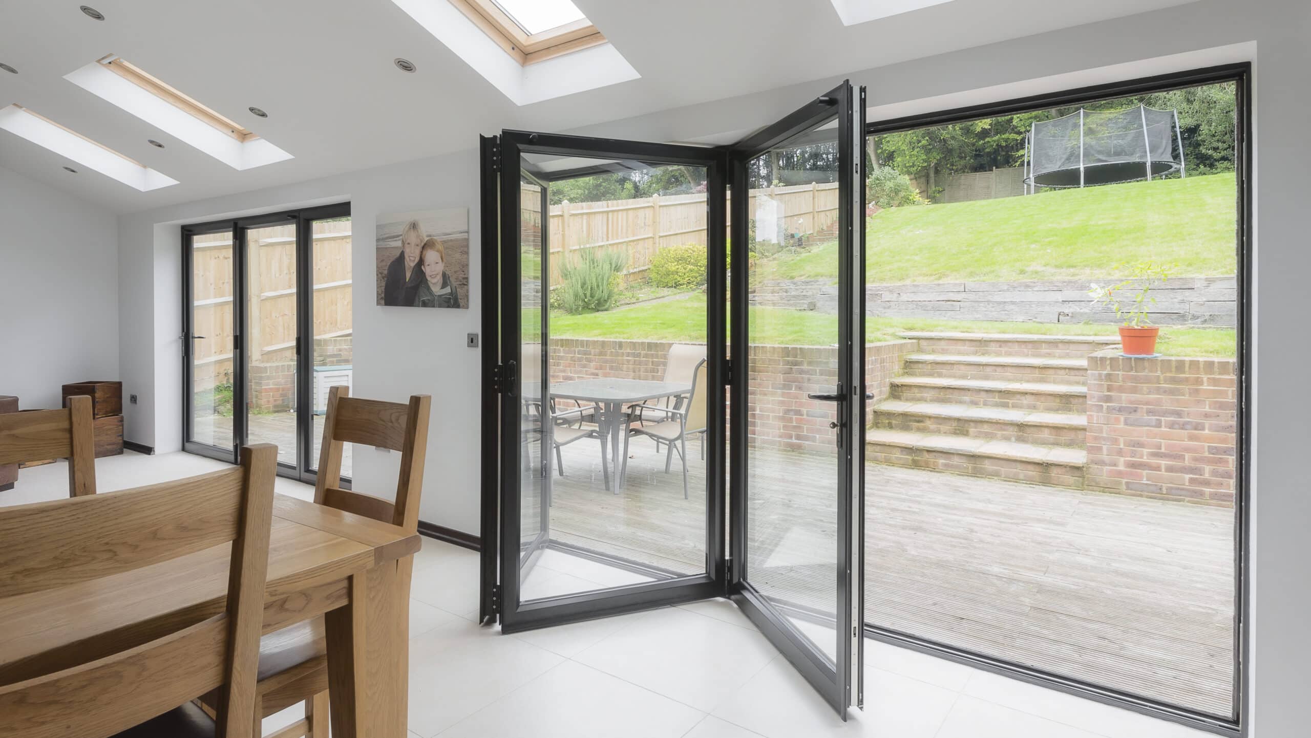 open in aluminium bifolding doors in a dining room.